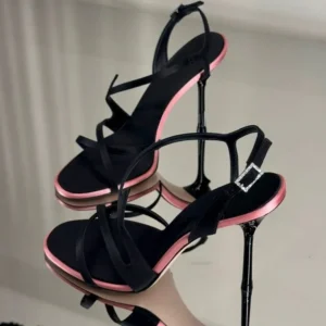 Black strappy high-heeled sandals with pink soles