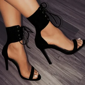 Black lace-up high-heel sandals on feet