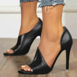 Black open-toe stiletto heels on feet