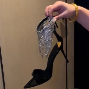 Hand holding black high heel with rhinestones