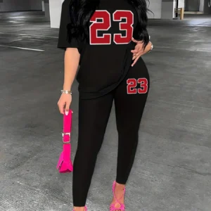 Person wearing black '23' outfit, pink bag