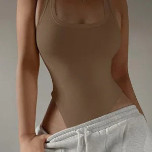 Person wearing brown bodysuit and gray sweatpants