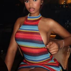 Woman in colorful striped halter dress seated