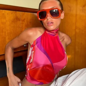 Person in colorful halter top and oversized sunglasses