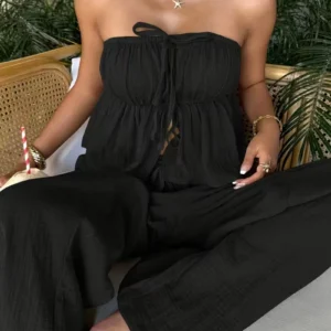 Woman seated in strapless black jumpsuit