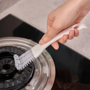 Hand cleaning gas stove burner with brush