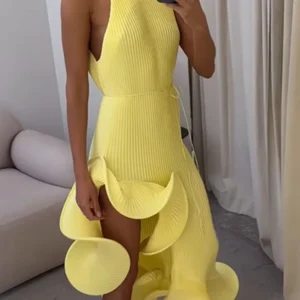 Person wearing yellow pleated dress with sculptural ruffles